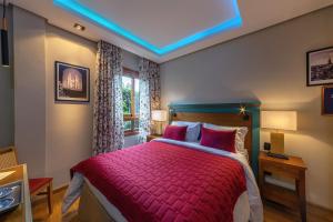 a bedroom with a bed with a red comforter at Hotel Britanico Express in Gramado