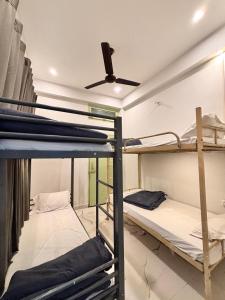 two bunk beds in a room with a ceiling fan at OLT Hostel Rishikesh in Rishīkesh