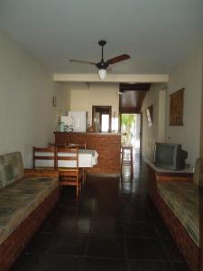 sala de estar con mesa y ventilador de techo en Casa aconchego Geribá canto direito 2Q com WiFi, en Búzios