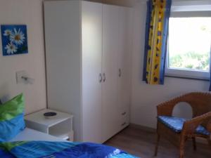 a bedroom with a bed and a chair and a window at Apartment Haus Jule by Interhome in Wervershoof