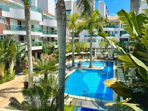 an aerial view of a hotel swimming pool with palm trees at Excelente Apto no condomínio Boulevard in Bombinhas