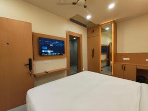 a bedroom with a white bed and a flat screen tv at Hotel Heritage Inn in Samastīpur