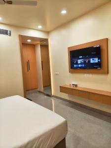a hotel room with a bed and a flat screen tv at Hotel Heritage Inn in Samastīpur +22 photos