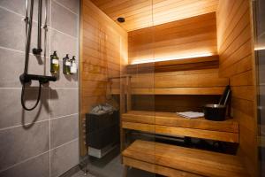 a shower in a bathroom with wooden walls at Riekko Lodge in Äkäslompolo +52 photos