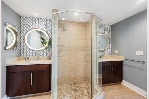 a bathroom with a shower and two sinks and mirrors at WS5103: 5103 Windswept in Kiawah Island +40 photos