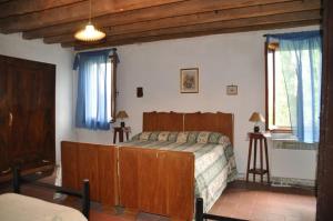 a bedroom with a bed in a room with blue curtains at Cá Scirocco in Ca Grignella