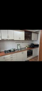 a kitchen with white cabinets and a stove at Rotonda apartment in Lugoj