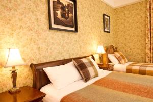 a hotel room with two beds and two lamps at Preston House in Abbeyleix