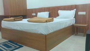 a large bed with white sheets and pillows on it at Hotel O V GUEST INN in Bhattiprolu
