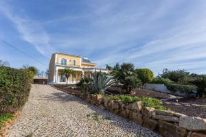 una gran casa amarilla con entrada de piedra en Villa Coelho by Trip2Portugal, en Olhão