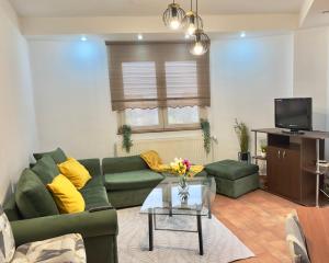 a living room with a green couch and yellow pillows at Rotonda apartment in Lugoj