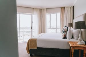a bedroom with a bed and a large window at The Riverside Hotel in Durban