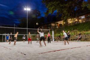 a group of people playing volleyball on a beach at hu Norcenni Girasole Village in Figline Valdarno