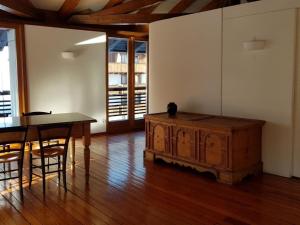 a dining room with a table and a wooden chest at Apartment mit Balkon by Interhome in Padola +5 photos