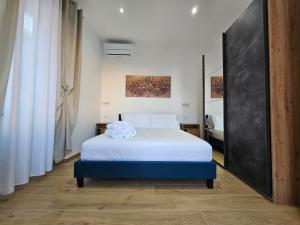 a bedroom with a white bed with towels on it at Olimpo Caserta in Caserta