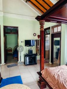 a bedroom with a bed and a tv in a room at Widi House in Nusa Dua
