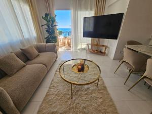 a living room with a couch and a table at Beach Front View Apartment Sea Pool & Prime Location in Limassol