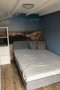 a bedroom with a bed with a painting on the wall at Apartment Tami by Interhome in Wervershoof