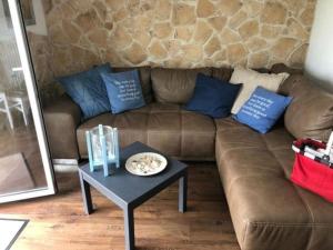 a brown couch with blue pillows and a table at Apartment Tami by Interhome in Wervershoof