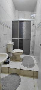 a white bathroom with a toilet and a shower at pousada Adriane in Rio do Sul