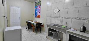 a kitchen with a sink and a table with chairs at pousada Adriane in Rio do Sul