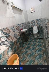 a bathroom with a sink and a toilet at Hotel karishna palace in Rīngas