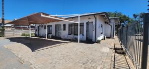 a patio with an umbrella on a house at RoomsAtRoseAve19 in Kuruman