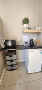 a kitchen with a black counter with a microwave at RoomsAtRoseAve19 in Kuruman