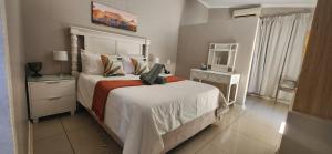 a bedroom with a bed with a laptop on it at RoomsAtRoseAve19 in Kuruman