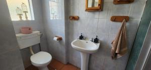 a small bathroom with a toilet and a sink at RoomsAtRoseAve19 in Kuruman