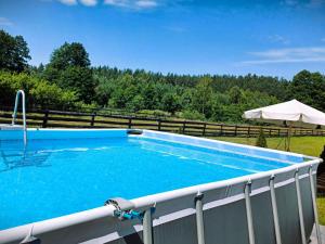 a swimming pool with a fence and an umbrella at Apartment by Interhome in Łukta