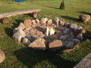 a stone fire pit with a bench and rocks at Apartment by Interhome in Łukta