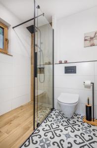 a bathroom with a glass shower and a toilet at Domki SOSNOWY PARK in Białogóra +116 photos