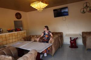 a woman sitting on a couch in a living room at Infinity 555 Lodge in Lusaka