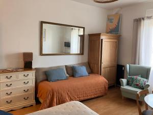 a bedroom with a bed and a dresser and a mirror at Studio phare de Biarritz Résidence Régina Golf in Biarritz