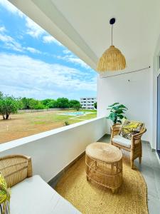 a living room with rattan furniture and a large window at Malindi Modern 2BR Near the Beach With a Private Pool in Malindi