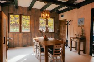 a dining room with a wooden table and chairs at Cabana Murmur -Riverside- in Valea Ierii