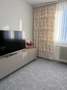 a living room with a flat screen television on a dresser at Eichhörnchenblick in Hahnenklee-Bockswiese