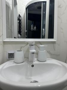 a white sink in a bathroom with a mirror at Apartments Velora in Kryvyi Rih