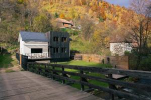 a barn on the side of a bridge at Cabana Murmur -Riverside- in Valea Ierii