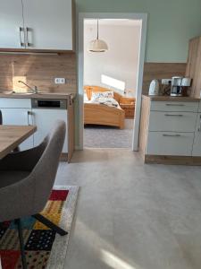 a kitchen and living room with a table and a bed at Eichhörnchenblick in Hahnenklee-Bockswiese