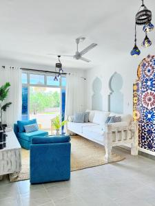 a living room with a white couch and blue chairs at Malindi Modern 2BR Near the Beach With a Private Pool in Malindi +53 photos