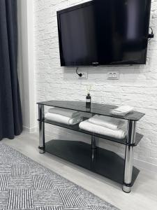 a black table with a television on a wall at Apartments Velora in Kryvyi Rih
