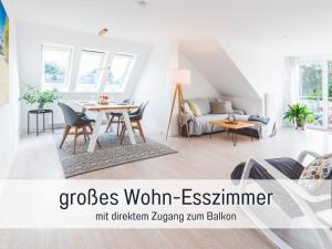 a living room with a table and a couch at Casa Ueberall - Ruhige DG-Ferienwohnung für 2 Erwachsene in Burg - Balkon mit Abendsonne, hochwertige Ausstattung, überdachter E-Bike-Stellplatz, Nähe zur Altstadt & Restaurants in Fehmarn