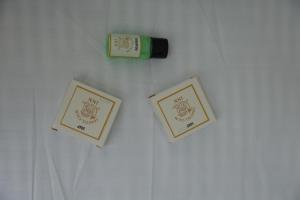 two framed pictures on a wall with a bottle of wine at Coastal Calm Inn in Fort Kochi