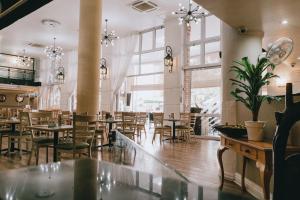 a restaurant with tables and chairs and windows at The Riverside Hotel in Durban