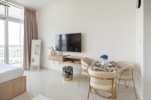 a white room with a dining table and a tv at Frank Porter - Carson A in Dubai Marina