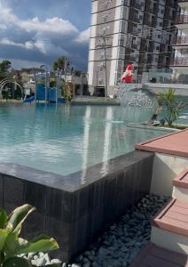 a swimming pool with a fountain in a city at Antara Condomium 2 studio unit in Talisay