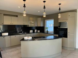 a large kitchen with white cabinets and a counter top at L'ancien rucher in Hotton