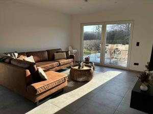 a living room with a couch and a table at L'ancien rucher in Hotton
